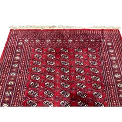 Persian Bokhara red ground rug, the field decorated with five columns of Gul motifs, the outer bands of the border with repeating lozenges, flanking repeating geometric motifs
