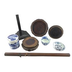 19th century Chinese cylindrical jar and cover decorated with a landscape in blue and white H11cm, Chinese blue and white saucer dish, small Japanese bowl, Chinese wooden pipe and Oriental plate stand and five further hardwood stands (10)