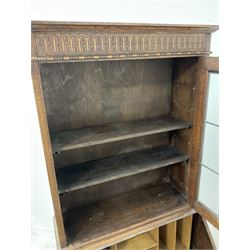 Early 20th century oak bureau bookcase, the projecting cornice over carved frieze and lead glazed doors, leading into bureau base with fall front and three drawers, raised on bracket supports