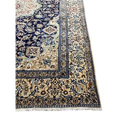 Persian nain ivory ground rug, silk inlaid, the central lotus medallion in an indigo field decorated with scrolling foliate patterns and flower heads with matching spandrels, the guarded border with trailing stylised floral motifs
