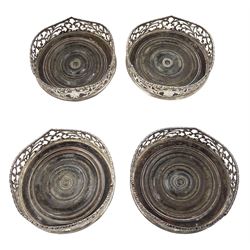 Set of four Victorian silver coasters with pierced sides engraved with a crest and with turned wooden bases D13cm London circa 1855 Maker Charles Boyton  Provenance: 2nd Baron Feversham