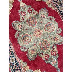 Small Persian red ground rug, the plain field with floral design medallion and spandrels, triple band border decorated with stylised flower head motifs