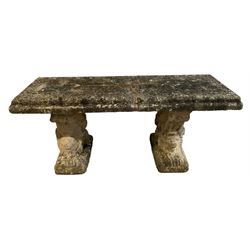 Three-piece weathered cast stone garden bench, rectangular top on recumbent lion end supports 