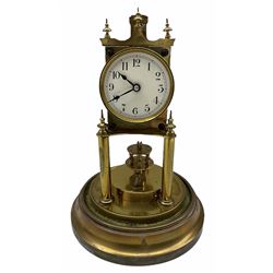 An early 20th century German torsion pendulum clock manufactured by Gustav Becker, with a cream enamel dial within a spun brass bezel, upright Arabic numerals with minute track and steel spade hands, 400-day spring driven movement with a rotary pendulum, clear glass dome on a circular brass effect base.