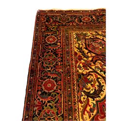Persian Meshed crimson ground carpet, large central medallion decorated with stylised plant and leaf motifs, the field with overall floral design with trailing branches, shaped spandrels decorated with further floral motifs, repeating border with guard bands