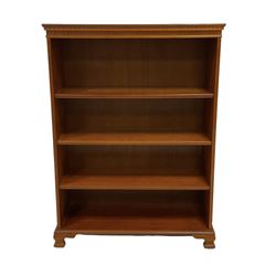 Late 20th century yew open bookcase, the crossbanded top over three adjustable shelves, raised on ogee supports 