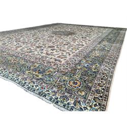 Persian ivory ground carpet, central eight-point star medallion decorated with peony motifs, the field decorated with interlacing foliage branches and stylised plant motifs, repeating scrolling border with overall floral design, within guard bands, signature panel to one end