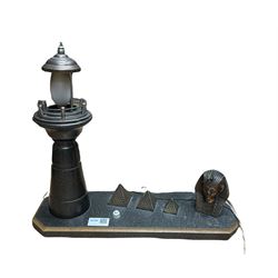 20th century table lamp in the form of a Lighthouse besides a Sphinx head and three graduated pyramids, L40cm 