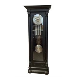 German - Hermle 'Nicolette' contemporary 8-day chiming longcase clock, ebonised case with a flat topped pediment and deep cornice, fully glazed door displaying three silvered case weights and a gridiron pendulum, on a stepped and moulded plinth with sliding draw, two part metal dial with a gilt bezel, pierced decoration to the centre and a silvered chapter, gilt Arabic numerals and contrasting steel hands, Hermle three train movement chiming the quarters and hours on two banks of 12 gong rods, with silent and chime selector playing Whittington, St Michael and Westminster chimes.
With winding key, three weights and pendulum.