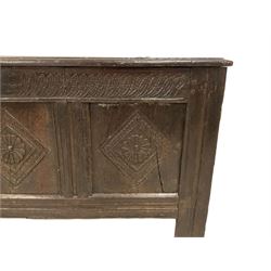 18th century oak coffer or chest, rectangular triple-panelled hinged top, the frieze carved with repeating leaf motifs in the form of flattened gadroons, over panels carved with concentric lozenges with central flower heads, on stile supports