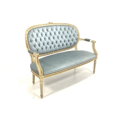 Louis XV style cream and gilt painted two seat sofa, with scrolled open arms, upholstered in buttoned blue velvet, raised on turned fluted supports 