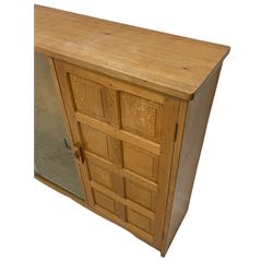 Beaverman - oak side cabinet, adzed rectangular top over two sliding glass doors and panelled door, the door handle carved with beaver signature, by Colin Almack, Sutton-under-Whitestone Cliffe, Thirsk