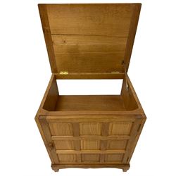 Fishman - adzed oak cupboard, hinged adzed top over panelled door, the handle carved with fish signature, the interior fitted with shelves, by Derek Slater, Crayke