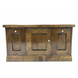 20th century solid oak filing cabinet sideboard, with two deep hanging file drawers flanking panelled cupboard enclosing fixed shelves, raised on skirted base 