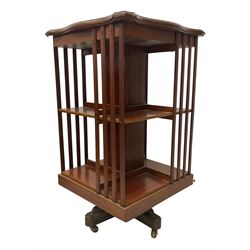 Edwardian inlaid mahogany two-tier revolving bookcase, shaped square top with foliate satinwood inlays and banding, on quadruform base with castors