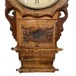 American -  late 19th century wall clock with an octagonal dial surround and parquetry work to the case, with carved side pieces, pendulum viewing door and an ogee base, painted dial with Roman numerals and minute track, twin train spring driven movement, striking the hours on a coiled gong. With pendulum.