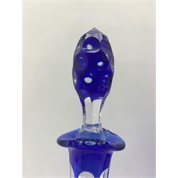 19th century Bohemian blue overlay glass bowl of pedestal form, engraved with a continuous scene of leaping deer in a woodland landscape, upon clear slice cut base, D23.5cm x H16cm, together with a pair of similar glass decanters, the bodies engraved with trailing grape and vine decoration, H37cm (3)