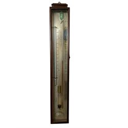  Mrs Janet Taylor, 104 Minories, London, England - Victorian mahogany cased Sympiesometer c 1860, glazed mahogany case with a cavetto moulded pediment, rectangular silvered register and Fahrenheit temperature scale, hydrogen gas filled syphon tube and a separate sliding vernier calibrated in barometric inches, to the left a separate mercury filled Fahrenheit thermometer and makers signature beneath, circular rotating recording disc within a curved aperture.
Mrs Janet Taylor is recorded as a barometer retailer and navigation teacher in London, England, 1845-1875.
The Sympiesometer patented in 1818 by the Edinburgh barometer maker Alexander Adie was an improved version of Robert Hooke's Thermobarometer. 
The hydrogen gas in the syphon tube is affected by both the temperature and air pressure. In order to take a reading the temperature is taken from the thermometer and the sliding vernier adjusted until the pointer on the top of the vernier corresponds with the temperature on the register scale. The barometric air pressure is then read from the top of the fluid in the syphon tube.   The Sympiesometer was thought to be a safer, reliable and more portable barometer for use primarily at sea. 
