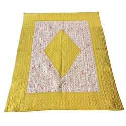 Vintage quilted patchwork bed cover, with mustard yellow border and matching central lozenge medallion on a pink and white floral ground, the reverse with a similar design, 170cm x 135cm