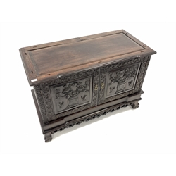  Late 19th century Chinese carved rosewood two door cupboard, profusely carved  with trailing leaf scrolls, rosed, urns and humming birds, raised on ball and claw feet, W111cm, H77cm, D53cm  