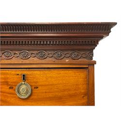 George III mahogany secretaire chest on chest, projecting moulded cornice with fluted cavetto and dentil, the frieze decorated with applied rosette motifs enclosed by interlaced scrolling border, fitted with two short and six long graduating drawers, maple lined drawers with cock-beaded facias, the secretaire drawer with fall front enclosing small pigeon holes, drawers and cupboard, circular pressed brass handle plates with central rosettes and hoop handles, lower moulding over bracket feet