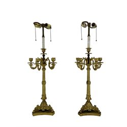 Pair of 20th century gilt metal table lamps, modelled as six branch candelabra, Regency style with ornate cast sconces and acanthus and scroll triform bases, H78cm 
