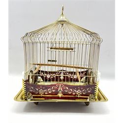Victorian brass birdcage, the sides inset with acid etched ruby glass panels, two opaque glass feeders and embossed brass base, the door impressed K.K. possibly produced in Birmingham, H39cm