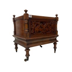 Victorian mahogany Canterbury or magazine rack, finias to each corner, three divisions with spindle uprights, the front panel pierced with foliate fretwork, over a cavetto apron, raised on turned feet with brass castors