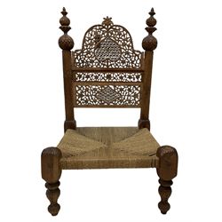 Indian style hardwood chair, profusely carved back panel over string seat 
