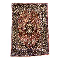 Persian Hamadan red ground rug, floral design medallion and spandrels, the field decorated with scrolling branches and stylised flower heads, guarded border decorated with stylised plant motifs