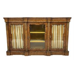 Victorian walnut credenza, the break front top over three glazed doors with gilt metal mounts, enclosing three fixed shelves, raised on a plinth base