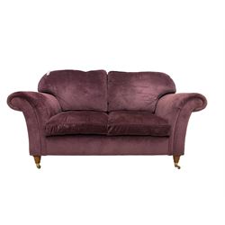 Two seat sofa upholstered in plum fabric raised turned front supports with brass castors