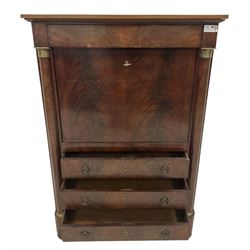 Early 19th century French Empire mahogany Secrétaire à Abattant, fitted with frieze drawer over a figured fall-front, enclosing central shelf with column supports over six assorted correspondence drawers, over three long drawers, flanked by recessed half-canted pilasters with embossed brass capitals, shaped skirted base o compressed bun feet