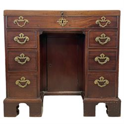 George III mahogany gentleman's kneehole dressing chest, rectangular hinged top concealing fitted interior with satinwood framed mirror, covered containers and open trays, over faux frieze drawer and six graduating drawers flanking the central cupboard, the sides flitted with twin sliding candle trays, lower moulded edge over bracket feet and castors

Provenance - property of a nobleman 