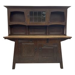 Attributed to Leonard Francis Wyburd for Liberty & Co. - Arts & Crafts  period oak dresser, raised back with shelves either side of cupboard enclosed by lead glazed door, the splayed angular base fitted with single drawer and two cupboards
