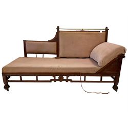 Aesthetic Movement mahogany framed chaise longue, brass cresting rail supported by lion masks, the back with reeded detail, apron pierced and carved with floral designs and Greek key pattern, raised on carved feet with castors, upholstered in pale pink textured fabric (W190cm D73cm H104cm); and pair matching armchairs, the back and and supports with geometric pierced and carved designs, stylised lotus carved to the apron (W65cm H99cm)