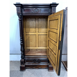 French stained walnut armoire wardrobe, frieze with leaf carved applied roundel, over bevelled mirrored door revealing birds eye maple lined panelled interior, fitted for hanging, flanked by leaf capped and fluted columns, single drawer to base, raised on moulded block supports, W121cm, H215cm, D61cm,