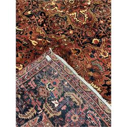 Persian Heriz golden red ground carpet, large floral medallion on field decorated with interlaced foliate, the border decorated with plant motifs