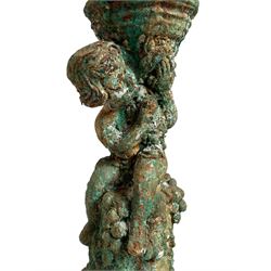 Victorian cast iron pedestal, Composite capital held aloft by sitting putto, the pedestal base draped in fruit and foliage, stepped and moulded circular base