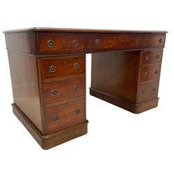 Victorian mahogany twin pedestal desk, moulded rectangular top with rounded corners, tan leather inset writing surface with gilt borders, fitted with nine drawers, each with circular pierced and press brass handle plates and loop handles, raised moulded plinth base