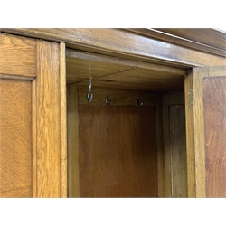Early 20th century panelled oak wardrobe, projecting cornice over single bevel edged mirror glazed door, each panel with quarter book matching, two drawers to base, W149cm, H198cm, D57cm