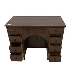 Regency mahogany kneehole desk, fitted with central drawer over arched recess and double cupboard, flanked by eight ebony strung drawers with turned ebony handles, lower reeded edge over square tapering supports with spade feet