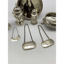 Victorian embossed silver circular salt London 1864, pair of Victorian silver pepperettes, silver circular photograph frame inset with a small jasper ware panel London 1905, three early 19th century silver decanter labels and a cylindrical pepperette 