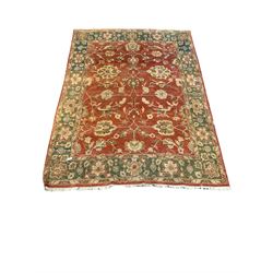 Persian style hand knotted ground rug, the red field with foliate and bird design enclosed by green border, 