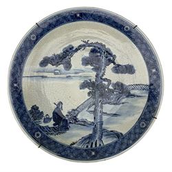 Chinese blue and white charger with crackle glaze, centrally painted with a figure seated beneath a pine tree within a fenced garden, four character mark beneath, D41cm 