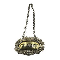 George III silver-gilt decanter label, by George Pearson, London 1818, of oval form with a Bacchanalian cherub and mask, with pierced trailing grapevine border and pierced 'Claret', L7cm