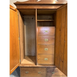 Edwardian pitch pine triple wardrobe, shaped arched pediment over bevelled mirror glazed door enclosing four drawers, flanked by two doors enclosing interior fitted for hanging, two drawers under, skirted base
