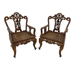 Pair Chinese carved hardwood armchairs, the cresting rail and centre splat pierced and carved with roses and scrolling decoration, the arm supports with stylised flowers in a geometric shape, panelled seat over carved scroll apron and cabriole supports