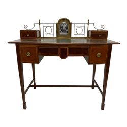 Edwardian inlaid mahogany writing table or desk, shaped top with pierced brass gallery back and central photograph with two trinket drawers, inset leather writing surface, fitted with central frieze drawer flanked by two short drawers, each with ebony and satinwood strung facias