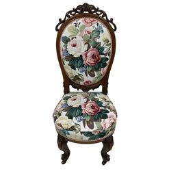 Victorian walnut nursing chair, pierced scrolling pediment, upholstered in Sanderson's 'Chelsea' floral pattern fabric, on scroll carved cabriole supports with brass castors